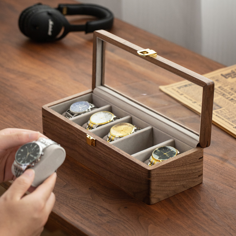 Five-slot walnut watch box showing individual compartments and an open glass lid