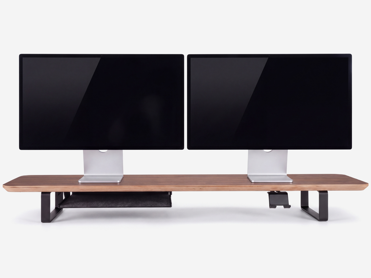 Two monitors resting on their original bases on a Musowood desk shelf