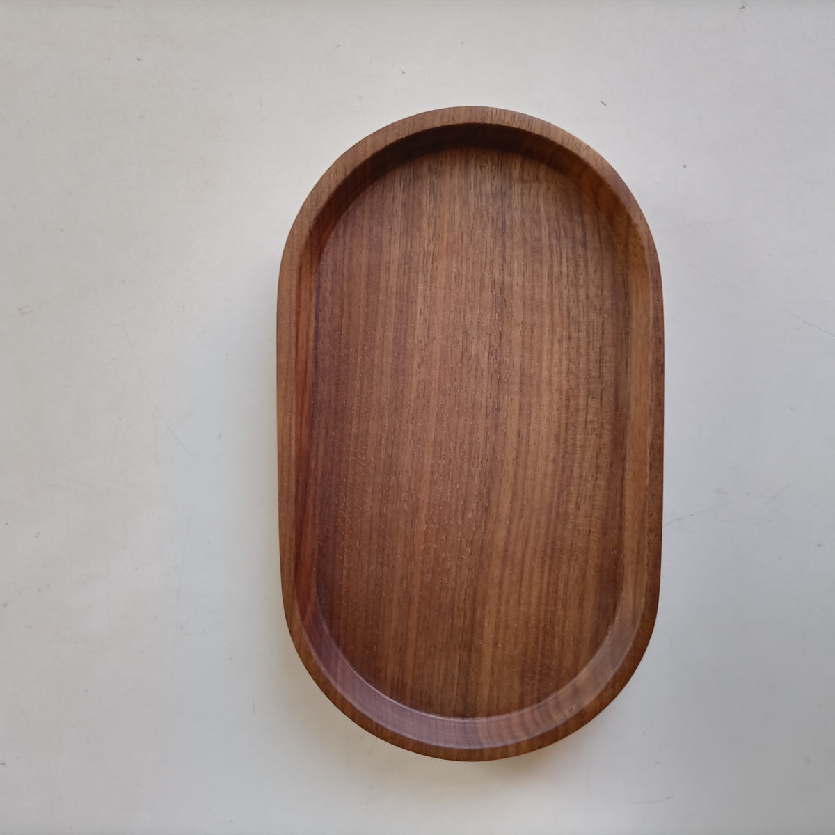 Top view of an oval walnut tray with a raised rim #material_Walnut